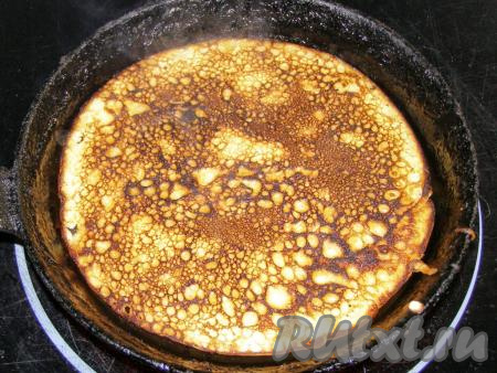 Переворачиваем поджаренный блин и обжариваем с другой стороны ещё, примерно, пол минуты (до золотистости) и перекладываем на тарелку. Так жарим все блины. Каждый раз, перед тем как залить очередную порцию теста, сковородку желательно слегка смазать подсолнечным маслом с помощью силиконовой кисточки или кусочка картофеля.