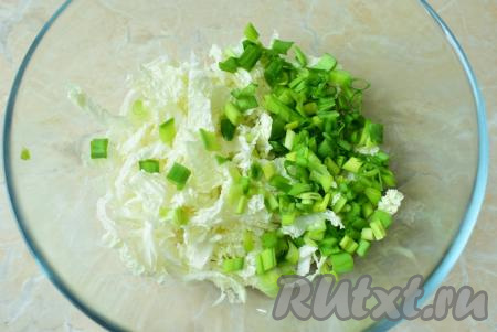 Зелёный лук ополосните, обсушите и нарежьте. Затем добавьте его в чашу к пекинской капусте.