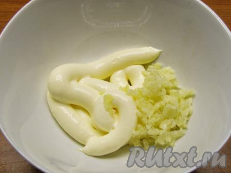 Для смазывания фаршированных окорочков смешиваем майонез и измельчённый прессом чеснок, по желанию, можно добавить приправу хмели-сунели (или любую другую приправу по вкусу). Смесью майонеза и чеснока обмазываем окорочка.