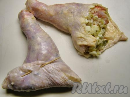 Куриную кожицу наполняем подготовленной начинкой достаточно плотно, придаём форму куриного окорока. Оставшимся краем кожи закрываем начинку и закрепляем зубочисткой, как на фото.