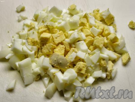 Яйца отвариваем в течение 8-10 минут после закипания воды, затем остужаем их под холодной водой, очищаем от скорлупы и нарезаем кубиками.