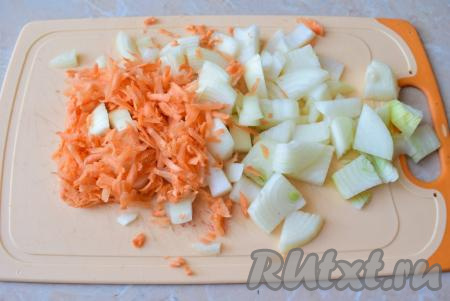 Пока кусочки курицы обжариваются, очистите луковицу и морковь. Лук нарежьте, а морковь натрите на крупной тёрке.