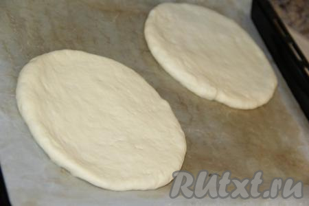 Раскатать каждую часть теста в круглую лепёшку толщиной, примерно, 1 см. Выложить узбекские лепёшки на противень, застеленный пергаментом.