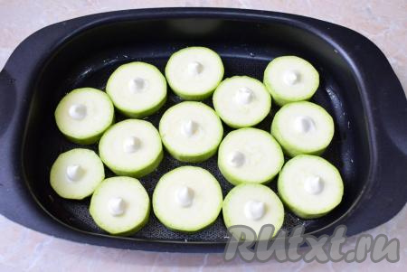 Форму для запекания смажьте растительным маслом и выложите нарезанные кабачки в один слой. На каждый кружочек нанесите немного майонеза.