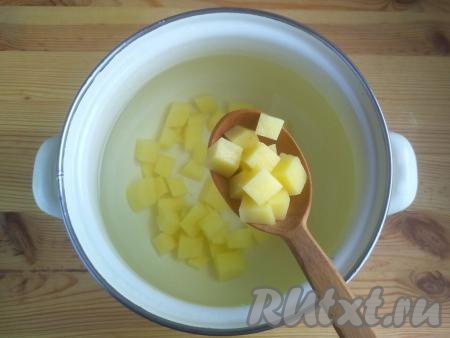 Картофель очистить, нарезать небольшими кубиками. Выложить картошку в кастрюлю, залить 1,5-1,7 литрами холодной воды, поставить на огонь и варить с момента закипания на среднем огне 10-12 минут.