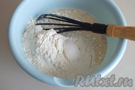 Всыпьте половину муки и начните перемешивать венчиком.
