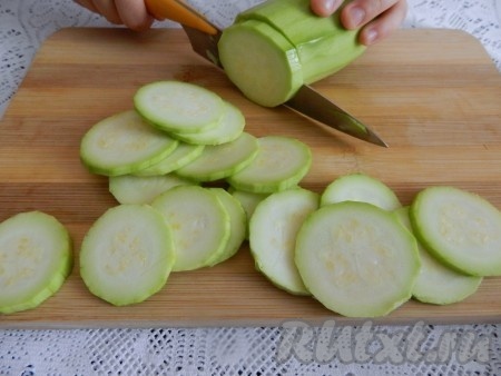 Когда тесто поднимется (по истечении примерно 40 минут), можно заняться овощами для начинки пиццы. Кабачок очистить от кожуры, а затем нарезать на тонкие кружочки.
