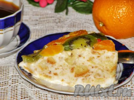 Нарезаем желейный торт с фруктами и бисквитом на порции и подаём к столу.