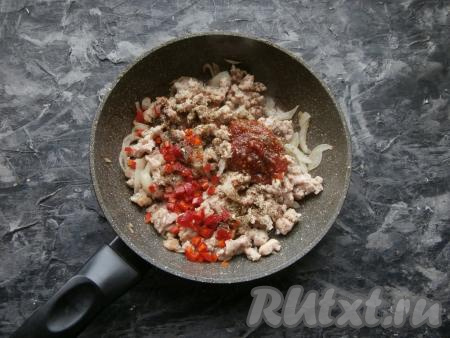 Обжарить фарш с луком в течение 4-5 минут, перемешивая, на среднем огне. Затем добавить соль, чёрный молотый перец, томатный соус, специи и мелко нарезанный перец чили.