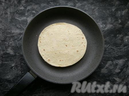 Накрыть второй лепёшкой, придавливая её к начинке. Через несколько секунд с помощью лопатки кесадилью перевернуть и подсушить вторую лепёшку в течение 2-3 минут. Аналогично приготовить вторую кесадилью.