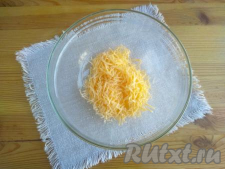 Выложить в миску сыр, натёртый на мелкой тёрке.