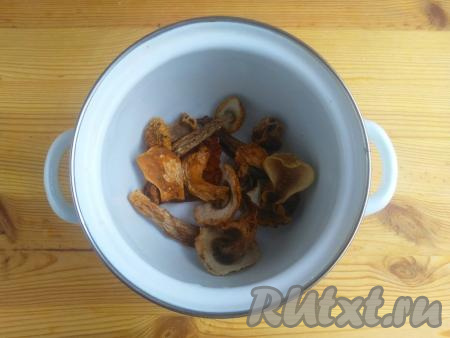 Сухие грибы ополоснуть проточной водой, выложить в кастрюлю.