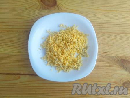 Оставшуюся половину яичного желтка натереть на мелкой тёрке.