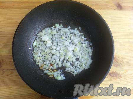 Лук очистить, нарезать мелко, выложить в сковороду с разогретым растительным маслом и обжарить на среднем огне до золотистого цвета (на это потребуется 3-5 минут), снять с огня и дать немного остыть.