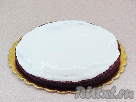 Теперь можно приступить к сборке черёмухового торта. На плоскую тарелку выложить нижний пласт коржа, обильно смазать сметанным кремом.