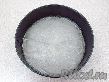 Взять разъёмную форму для выпечки (у меня форма диаметром 21 см), раскрыть её, снять боковую часть, а на дно формы положить лист бумаги для выпечки. Снова надеть боковую часть и, прижав бумагу, защёлкнуть форму. Дно формы смазать маслом и обсыпать мукой (или манкой). Стенки формы ничем смазывать не нужно.