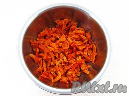 По прошествии минут 5 переложить курагу в дуршлаг, дать стечь жидкости, а затем обсушить с помощью салфетки и нарезать соломкой.