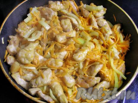 Перекладываем в сковородку с обжаренной свининой нарезанные лук и чеснок, добавляем натёртую морковку, перемешиваем и обжариваем на среднем огне, помешивая время от времени, около 5-7 минут.