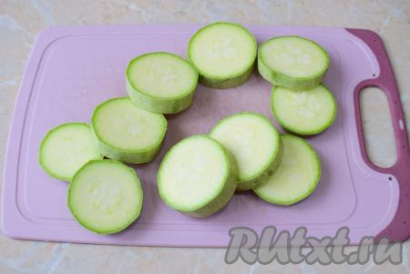 Для жарки выбирайте молодой кабачок. У такого кабачка мягкая кожура и ещё не созрели семечки внутри. Кабачок помойте и отрежьте с двух сторон хвостики, кожуру можно не очищать. Нарежьте подготовленный кабачок на кружочки толщиной 1,5-2 см.