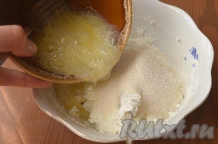 К творогу добавить сахар, сметану, ванилин, яйца, тщательно перемешать.