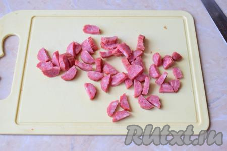 Колбасу нарежьте небольшими кусочками.