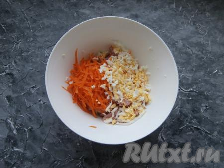 Свежую морковку и варёные яйца натереть на крупной тёрке, а затем выложить в салат из свежей капусты и колбасы.