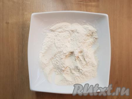 В глубокую тарелку насыпать муку, разрыхлитель теста, соду и хорошо перемешать ложкой получившуюся смесь сухих ингредиентов.