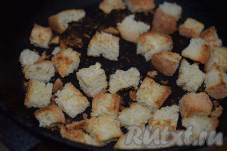 Сковороду разогреть (смазывать сковородку маслом не нужно), выложить хлебные кубики, жарить сухарики на сухой сковороде, периодически помешивая, примерно, 8-10 минут, огонь должен быть умеренным, чтобы сухарики успели подсушиться и не пригорели. Готовые сухарики убрать с огня, дать им остыть.