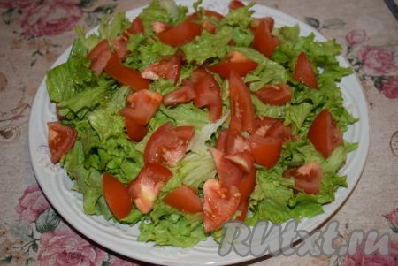 Помидоры нарезать на дольки и выложить поверх листьев салата, слегка присолить овощи.