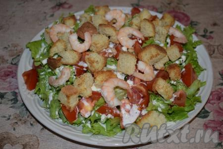 Листья салата и помидоры заливаем заправкой, сверху выкладываем сухарики и креветки. Наш постный салат "Цезарь" с креветками готов. Подаём его сразу к столу, а перемешиваем уже во время еды.