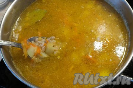 Затем выложите в суп варёные горох и перловку, доведите до кипения, а после этого варите на минимальном огне минут 15-20. За 5 минут до готовности добавьте лавровый лист.