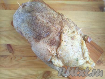 Внутрь утки выложить подготовленную начинку из риса и овощей. Места разреза фаршированной утки скрепить зубочистками, полностью закрывая начинку (как на фото). Кожу на шее вывернуть внутрь, также скрепить зубочисткой.