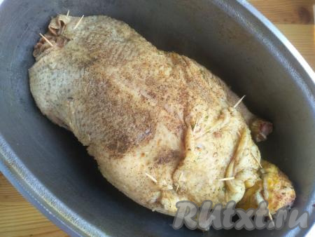 Переложить нафаршированную тушку в утятницу, поставить в разогретую до 220-230 градусов духовку. Запекать утку в течение 1 часа 10 минут. За это время 3-4 раза полить тушку выделившимся жиром. Накрыть утятницу крышкой, огонь уменьшить до 190 градусов и запекать утку в духовке ещё 30-50 минут. Готовность тушки проверяется с помощью прокола вилкой в самом толстом месте около ножки. Выделившийся сок должен быть прозрачным.