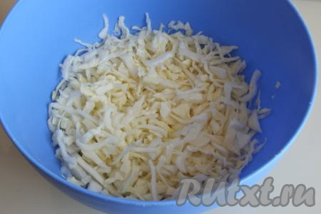 Нашинкуйте капусту тонкой соломкой и переложите в просторную миску.

