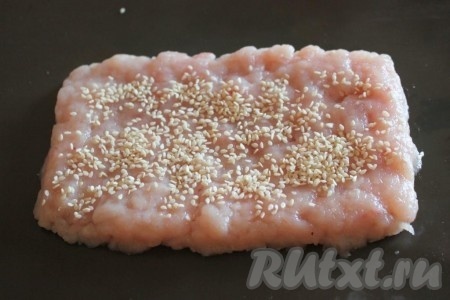 Из 1/5 части фарша сделайте пласт толщиной около 1 см, посыпьте его кунжутом.