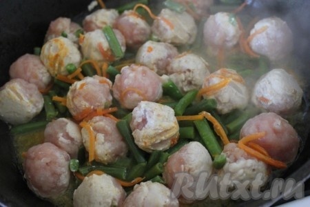 Из остального фарша сформируйте круглые фрикадельки, обжарьте их на растительном масле и потушите их до готовности вместе с морковью по-корейски и стручковой фасолью, которую предварительно ополосните в воде для удаления ледяной глазури.