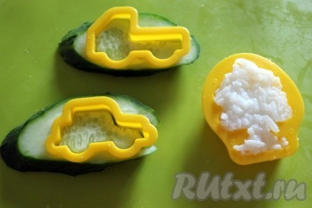 Деткам будет интересно, если из белого риса сформировать фигурку, а из огурца и запеченного куриного фарша формочками вырезать какие-либо фигурки.