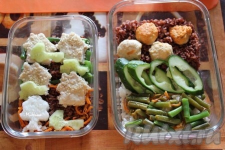 Для взрослой порции бенто ланча на красный рис уложите куриные фрикадельки, а на белый рис - овощи, добавьте огурец, т.е. у меня обрезки огурца, кубики феты и зелень.