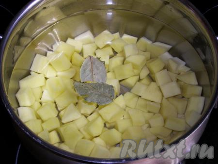 Перекладываем картофель в кастрюлю, в которой будут вариться щи, заливаем 2 литрами свежей холодной воды, добавляем соль и лавровые листья. По желанию, можно положить в воду с картофелем стебли укропа, очищенный корень петрушки, а также горошинки чёрного и душистого перцев. На сильном огне доводим воду до кипения, затем огонь уменьшаем и варим картофель минут 15-20 (до мягкости).