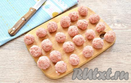 Мясной фарш посолить и поперчить по вкусу, тщательно перемешать. Скатать из фарша небольшие шарики (по размеру чуть меньше грецкого ореха) - фрикадельки. У меня получилось 23 штуки.