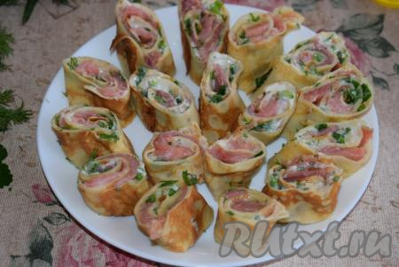 Далее выкладываем закуску на блюдо срезом вверх. Отправляем рулетики из блинов с красной рыбой в холодильник на пару часов для того,&nbsp;чтобы закуска охладилась и пропиталась.