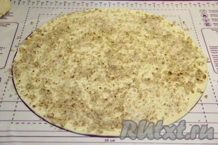 Оба раскатанных круга равномерно присыпать ореховой начинкой.