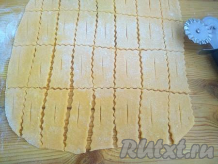 С помощью фигурного роликового ножа (или обычного ножа) нарезать тесто на прямоугольники&nbsp;размером 2 см на&nbsp;4 см. В центре каждого прямоугольника сделать&nbsp;надрез, не доходя до края.