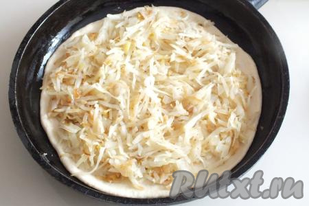 Возьмите сковороду (или форму для выпечки) диаметром 26-28 см, смажьте тонким слоем растительного масла, выложите одну раскатанную часть теста. Разложите равномерно на тесто, немного отступив от края, остывшую начинку.