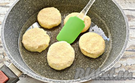 В сковороду влить растительное масло, прогреть его. Творожные заготовки обвалять в панировочных сухарях со всех сторон и прижать немного. Сырники выложить в сковороду, оставляя между ними пространство.