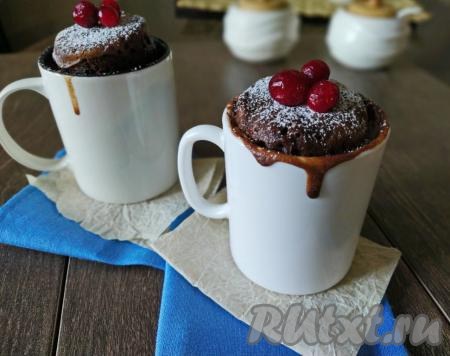 Вкусный, пышный шоколадный кекс, приготовленный в кружке в микроволновке, сверху посыпаем сахарной пудрой, украшаем ягодами и подаём к чашечке чая.