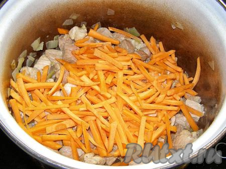 Перекладываем в кастрюлю нарезанную морковь, разравниваем её по поверхности.