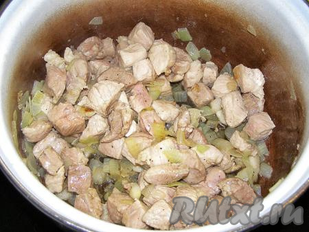 Кладём в кастрюлю с луком нарезанное мясо, по желанию, добавляем свежемолотый чёрный перец, перемешиваем и жарим, пока мясо не посветлеет со всех сторон.