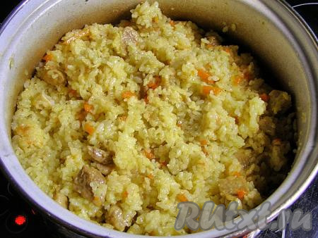 Аккуратно, снизу вверх перемешиваем плов так, чтобы мясо, лук и морковь равномерно распределились по рису.