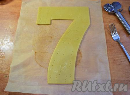 "Отдохнувшее" тесто разделите на 3 равных части. Каждую часть теста на пергаменте раскатайте в пласт толщиной, примерно, 4-5 мм и вырежьте из них по заранее заготовленному шаблону цифру 7. У меня высота цифры 30 см. Всего должно получиться 3 коржа в виде цифры 7. Каждый корж по всей поверхности проткните вилкой. Выпекайте каждый корж в разогретой духовке в течение 5-7 минут при температуре 180 градусов. Готовые медовые коржи полностью остудите.